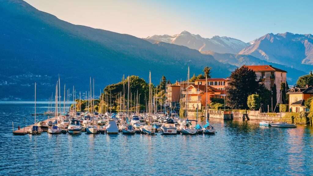 Bellano, Vista do Lago de Como com barcos e montanhas ao fundo.